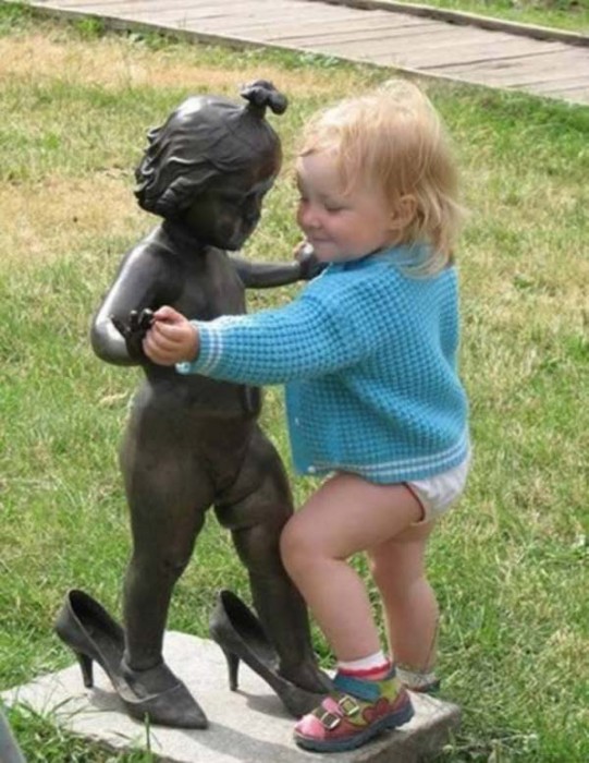 Niña bailando con una estatua