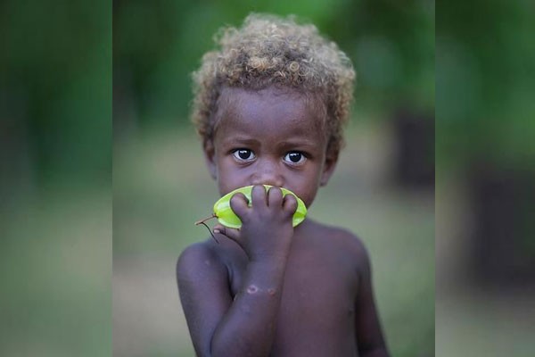 Este pequeño comiendo una fruta