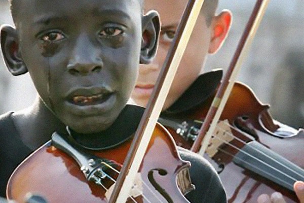 Un niño tocando el violín y llorando