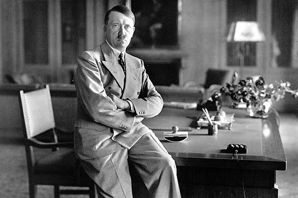 Hitler sentado sobre su escritorio