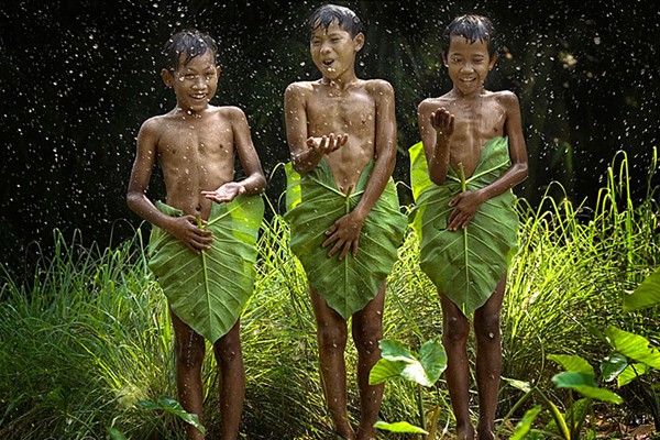 Pequeños disfrutando debajo de la lluvia