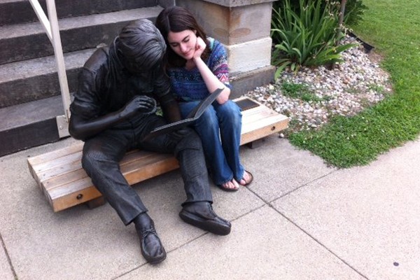 Una chica y una estatua leyendo juntos