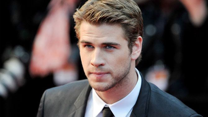 Liam Hemsworth haciendo surf