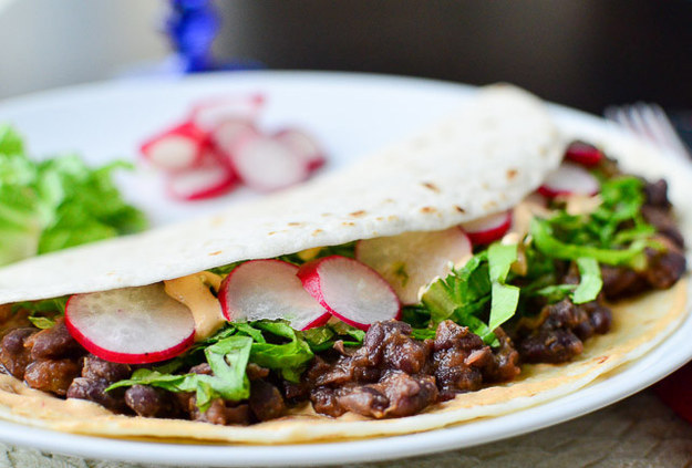 Tacos con frijoles negros, rábano y queso picante