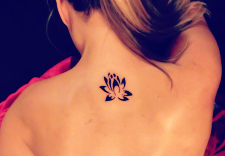 Simple tatuaje de loto en la espalda alta