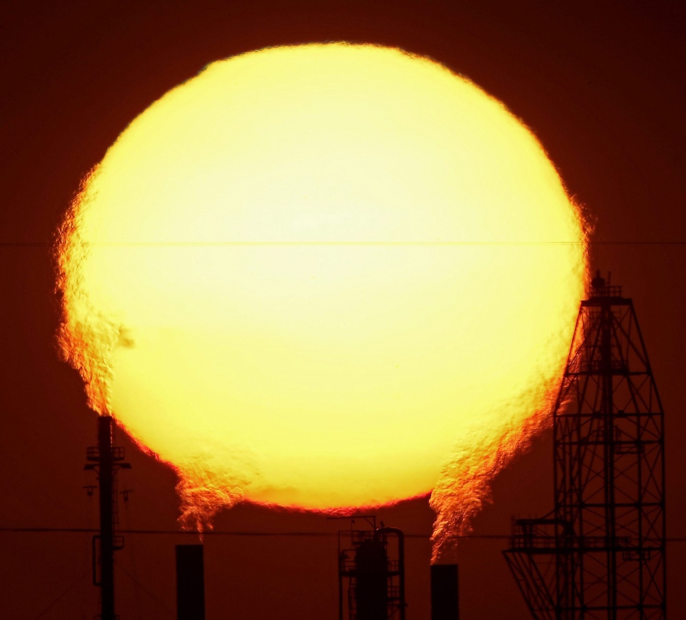 El sol entre las chimeneas de las fábricas